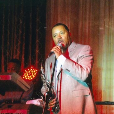 A Man Speaking into a Mike Wearing a Suit