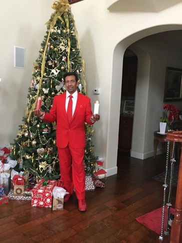 A Man in a Red Suit in Front of a Christmas Tree