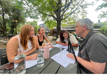 In the Adelaide Hills, a participant enjoys social time with three support workers during a dinner,