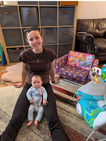 In Adelaide, South Australia, a support worker enjoys disability care with a baby while sitting on a