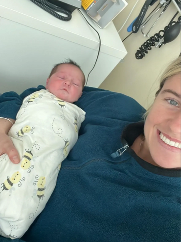 Support worker with a client’s baby in their arms, showing person centred disability care and NDIS s