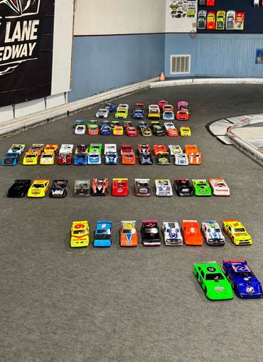 Rows of colorful toy race cars lined up on an indoor track.