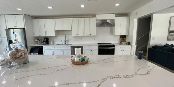 White kitchen with black appliances - white veined countertop.
