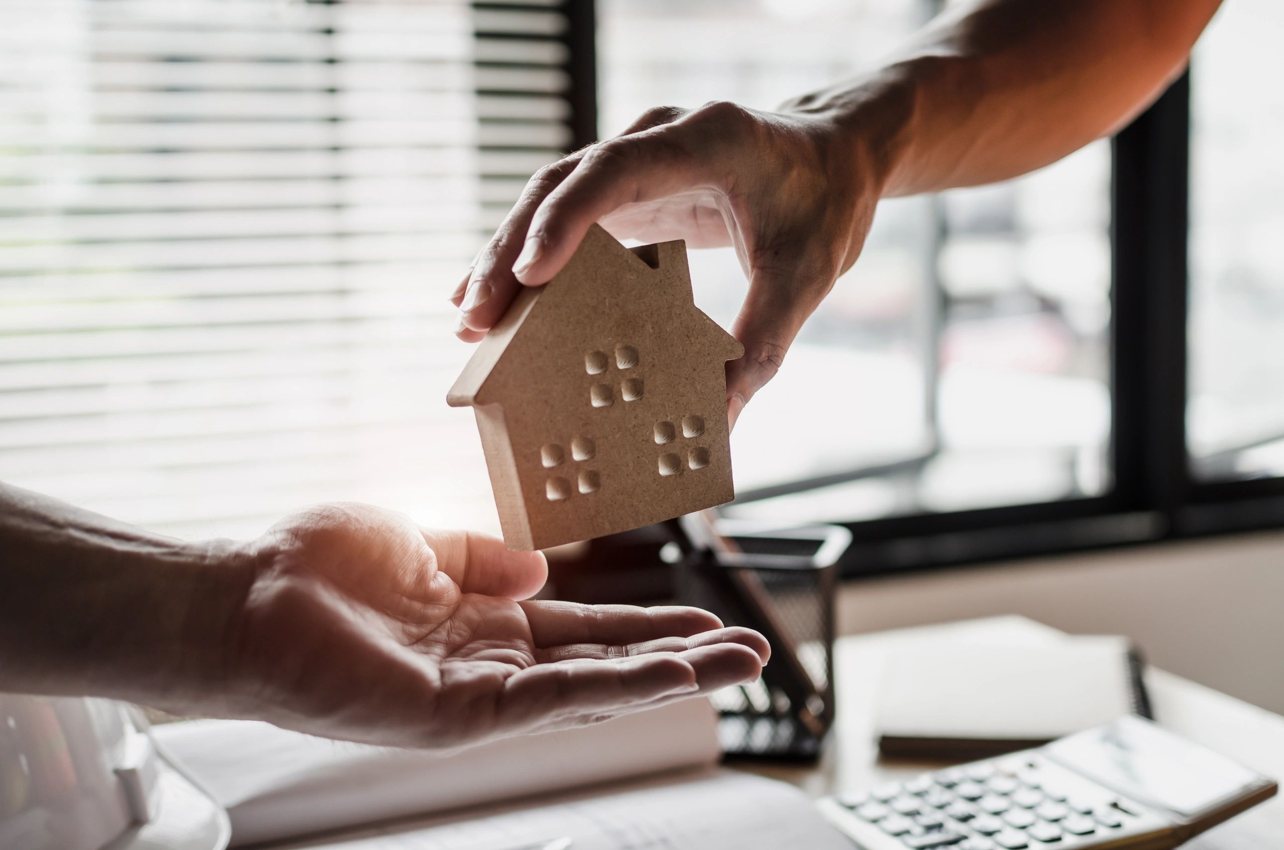 A real estate agent giving a wooden tiny house to a client