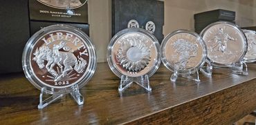 A row of collectible silver Liberty coins displayed on stands.