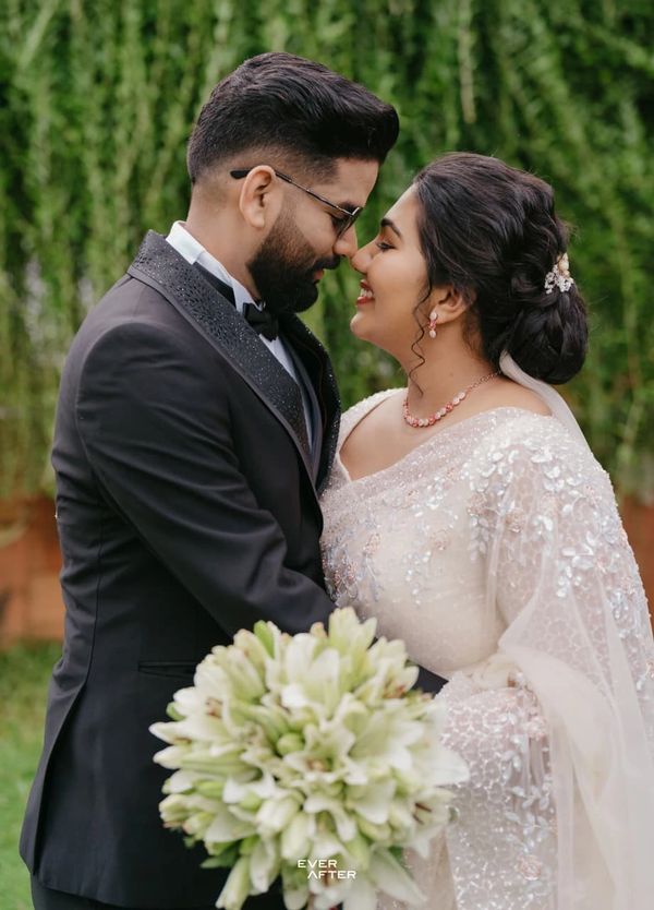 A couple shares an intimate moment on their wedding day, surrounded by nature.