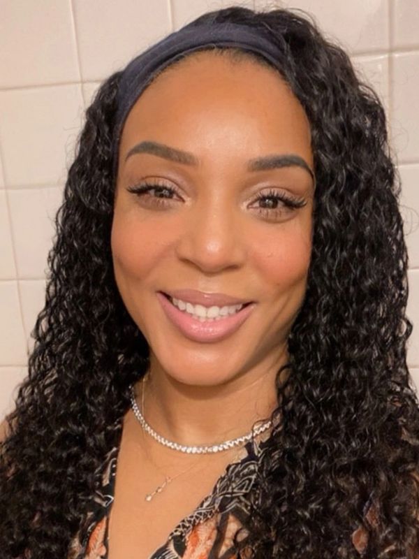 Smiling woman with curly hair and headband.