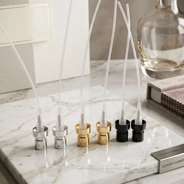 Six metal perfume spray nozzles in silver, gold, and black on a marble tray.