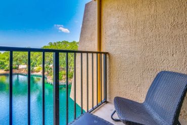 Private Balcony view off of master bedroom overlooking a lagoon with a black chair.