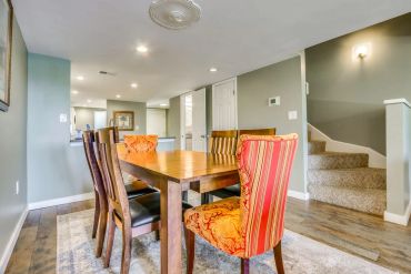 Dining room with wooden table and mixed chairs.