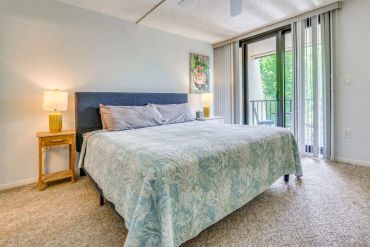 Bright bedroom with a large bed and balcony access.