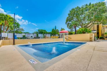 Empty kids pool with fountain and mushroom water feature.