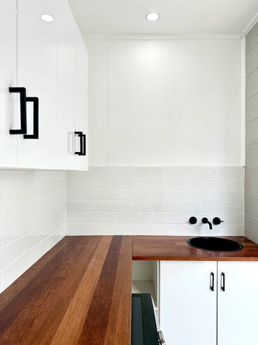 Laundry Renovation using subway tiles, bench tops and gloss white cupboards
