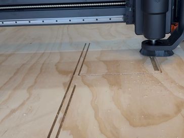 CNC machine cutting grooves into wood.