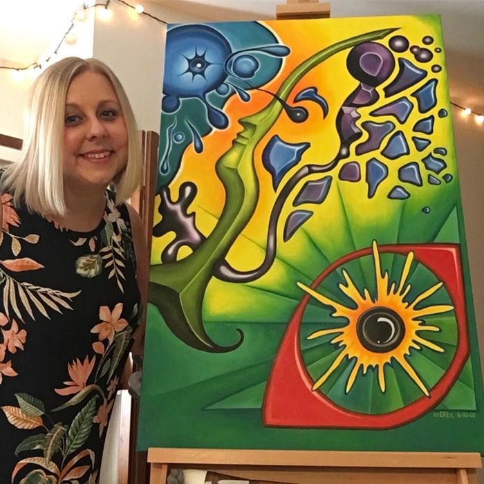 Andrea Luttenberger posing with her painting, Fragmented Reality
