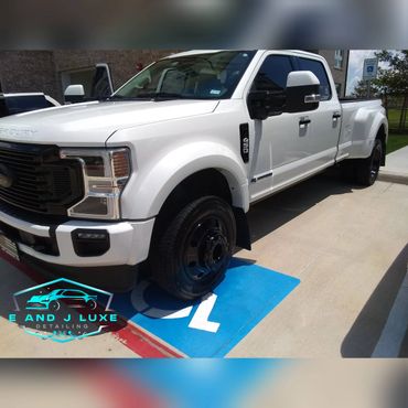 White Ford pickup truck parked in a handicapped spot outside a building.