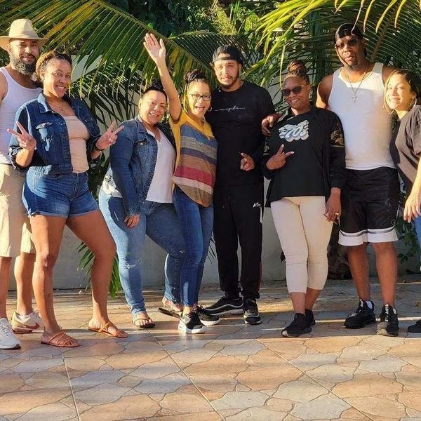 Group of friends posing outdoors with smiles and peace signs.