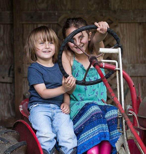 Riya and Rafi hanging out on our tractor.  Photo credit Kelley Lynch.