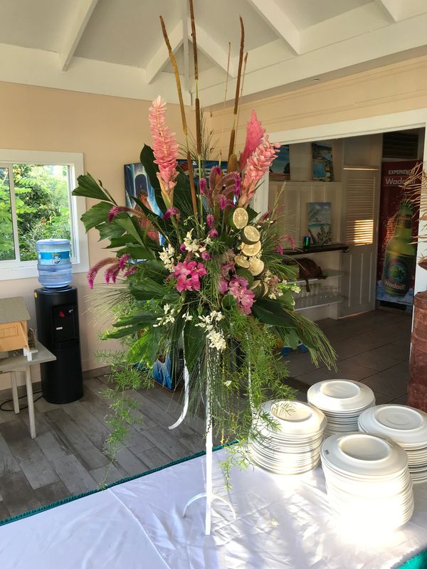 Innenansicht eines Restaurants in Antigua. Tropischer Tischschmuck, pink und grün in langem Ständer