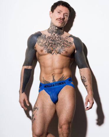 Man with tattoos wearing blue "MOLLY & TOMMY" underwear.