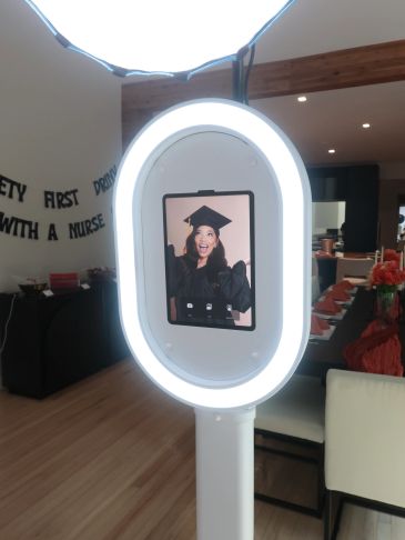 Ring light with phone displaying a graduating woman.