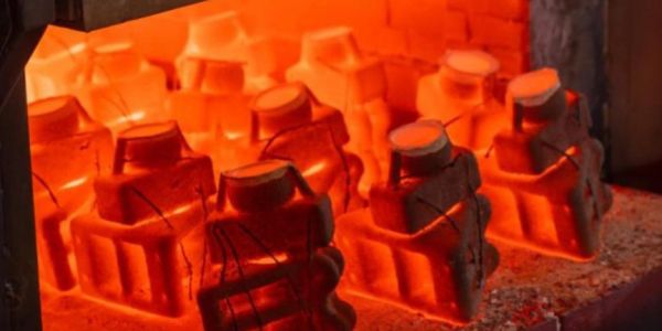 Heated metal parts glowing red in a furnace.