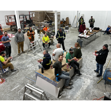Construction workers enjoying a pizza break inside a warehouse.