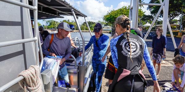 Ocean Ramsey helping people on and off the shark dive boat in Haleiwa