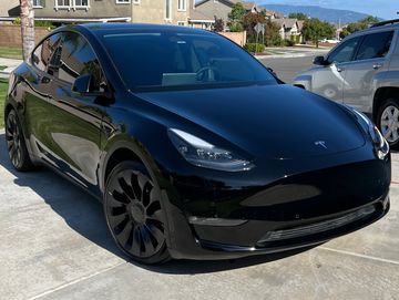 Black Tesla Model Y shining from a fresh wax