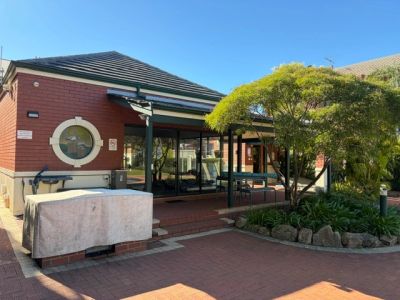 Residential building with a small covered entrance and garden.