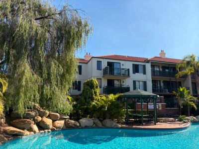 Apartment complex with outdoor pool and gazebo.
