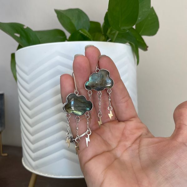 Labradorite cloud earrings with brass lightning bolts hanging from chains at the bottom.