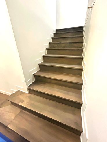 Modern wooden staircase with white walls and unique zigzag trim.