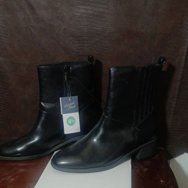 Pair of black leather ankle boots with a size tag attached.