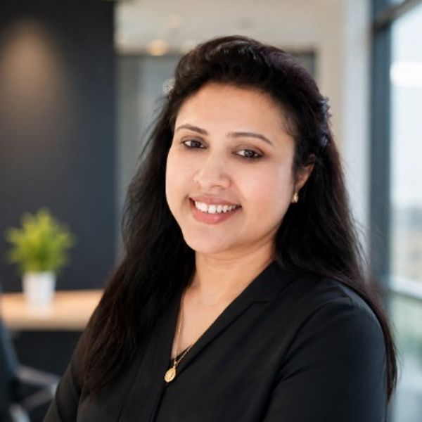 Smiling woman with long dark hair in a modern office.