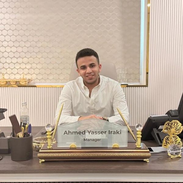 Ahmed Yasser Iraki posing behind his desk.