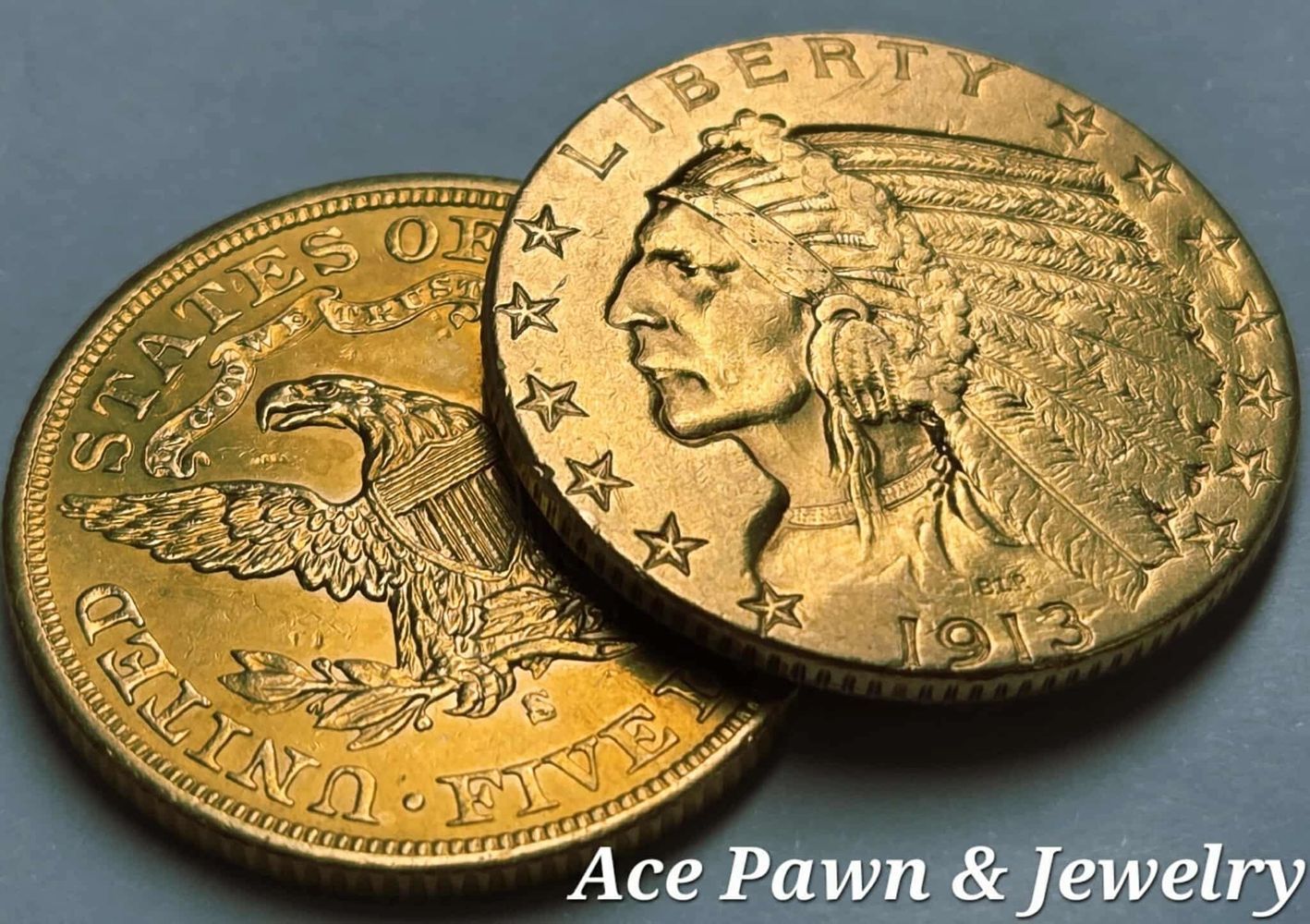 Close-up of two gold coins, one dated 1913 with a Native American profile.