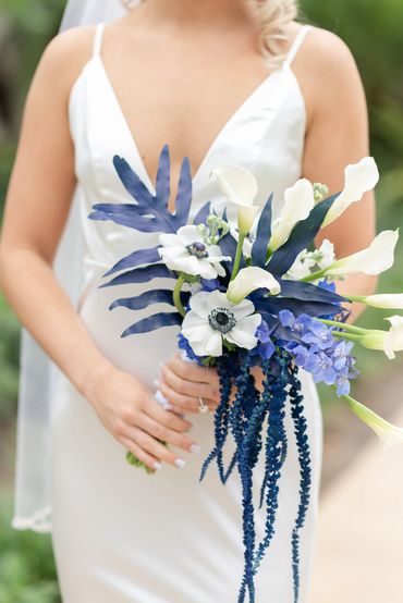 Non traditional bridal bouquet with a tropical flair. Calla lilies with anemones and blue flowers