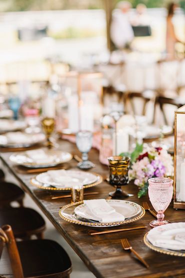 Assorted glassware in pink and blue on wooden family reception table