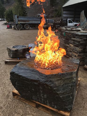 Custom fire feature using a core-drilled Kent Falls boulder with natural color and texture.