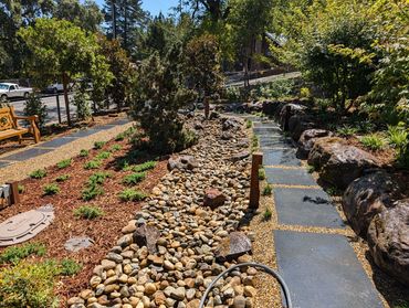 Black limestone path with Yosemite Cobble creek bed and Triple Head Sonoma Fieldstone wall