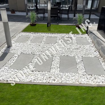 Modern garden with concrete slabs and white stones.