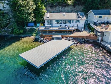 Lakeside house with a large dock and a peaceful waterfront view.
