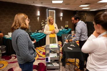 people gather as they watch man in suite with black slacks and button up work ozone therapy machine