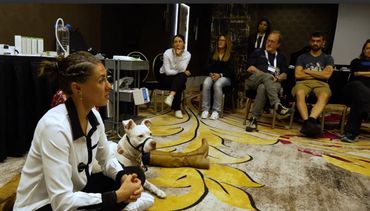 Woman sitting next to white dog discussing the benefits of ozone therapy for animals.