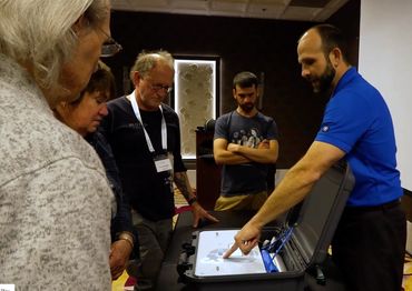 man in blue polo shirt pointing to information in briefcase at ozone therapy training workshop