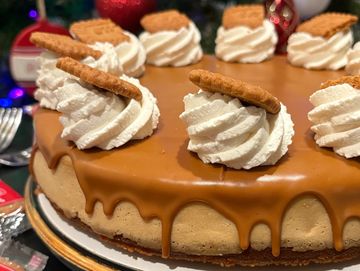Caramel cheesecake with whipped cream and cookie toppings.
