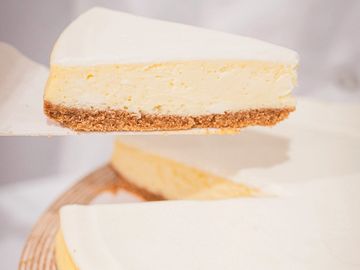 Slice of creamy cheesecake with crumb crust.
