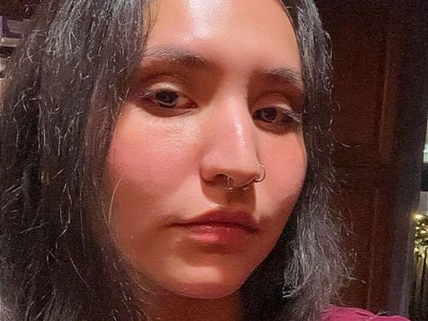 Close-up portrait of a woman with dark hair and septum piercing.
