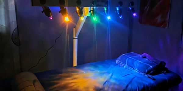 Therapy bed with colorful light therapy bulbs above.